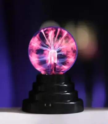 Pointe de décharge électrique visible avec éclairs lumineux violets et roses, illustrant un phénomène scientifique fascinant.