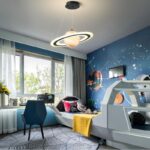 Chambre d'enfant décorée avec un thÚme spatial, comprenant un lit en forme de navette spatiale, un mur peint avec des planÚtes et étoiles, et une décoration inspirée de l'espace.