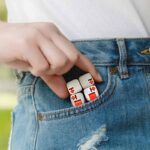 Jeu de cubes éducatifs avec chiffres et symboles dans la poche d'un jean, illustrant un objet scientifique ludique et éducatif.