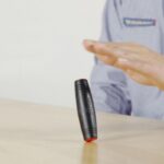 Bâton lumineux scientifique en rotation, utilisé pour des démonstrations éducatives ou des expériences scientifiques, posé sur une surface plane.