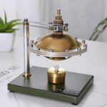 Presse-papiers scientifique en laiton avec mécanisme en métal, décoratif et fonctionnel, idéal pour décoration de bureau ou collection d'objets scientifiques.