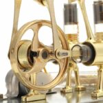 Véritable machine de laboratoire en laiton doré, avec engrenages et composants précis, utilisée pour des expériences scientifiques ou des démonstrations éducatives.