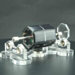 Pompe à vide en verre et métal, utilisée pour des expériences scientifiques ou des démonstrations de physique, avec un design élégant et moderne.