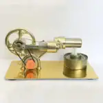 Modèle miniature de piston à vapeur en laiton doré, avec roue et cylindre, utilisé comme objet de décoration scientifique ou collection.