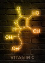 Élément chimique de vitamine C en néon lumineux, affiché sur un mur en briques, illustrant la composition moléculaire de la vitamine essentielle pour le système immunitaire.