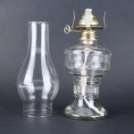 Pied à soufflerie en verre avec composant métallique, utilisé pour des expériences scientifiques ou comme décoration de style vintage.