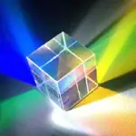 Cube en verre transparent projetant des lumières colorées bleues, vertes, jaunes et roses, créant un jeu de reflets et d'ombres sur une surface sombre.