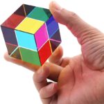 Cube coloré en plastique avec main humaine, utilisé comme objet de décoration scientifique ou éducative.