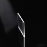 Panneau en verre transparent utilisé dans des expériences scientifiques, posé sur une surface noire pour mettre en valeur sa clarté et sa finesse.