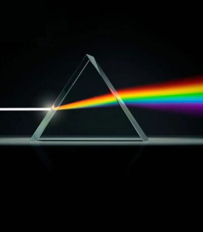 Illustration d'un prisme en triangle dispersant la lumière blanche en un spectre de couleurs arc-en-ciel, symbolisant la dispersion de la lumière et la science optique.