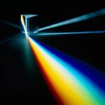 Illustration d'une porte en verre avec un faisceau lumineux coloré passant à travers, créant un effet visuel captivant et scientifique.