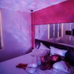 Lampe de projection d'étoiles créant un ciel nocturne magique dans une chambre à coucher.