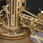 Détail d'une horloge mécanique en bois avec engrenages et aiguilles, mettant en valeur la précision et l'artisanat du design scientifique.