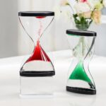 Sablier décoratif avec sable rouge et vert, design moderne et élégant, parfait pour une décoration de style scientifique ou contemporain.