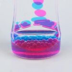 Pots de liquide coloré avec bulles et gouttes suspendues, illustrant une expérience scientifique ou une décoration innovante.