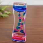 Vase en verre transparent orné de motifs abstraits bleus, roses et transparents, idéal pour la décoration scientifique ou moderne.