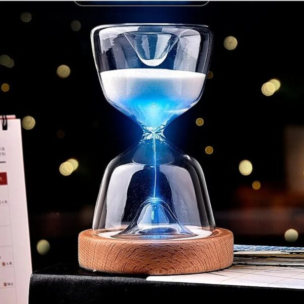 Sablier lumineux en verre avec lumière bleue, posé sur un socle en bois, créant un effet visuel captivant. Parfait pour la décoration de bureau ou comme objet de collection scientifique.