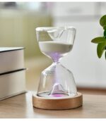Horloge sablier en verre avec sable blanc, symbole du temps qui passe, posée sur un socle en bois naturel. Parfait pour la décoration scientifique ou comme objet de collection.