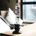 Instrument scientifique de laboratoire avec liquide et billes flottantes dans un environnement intérieur moderne.