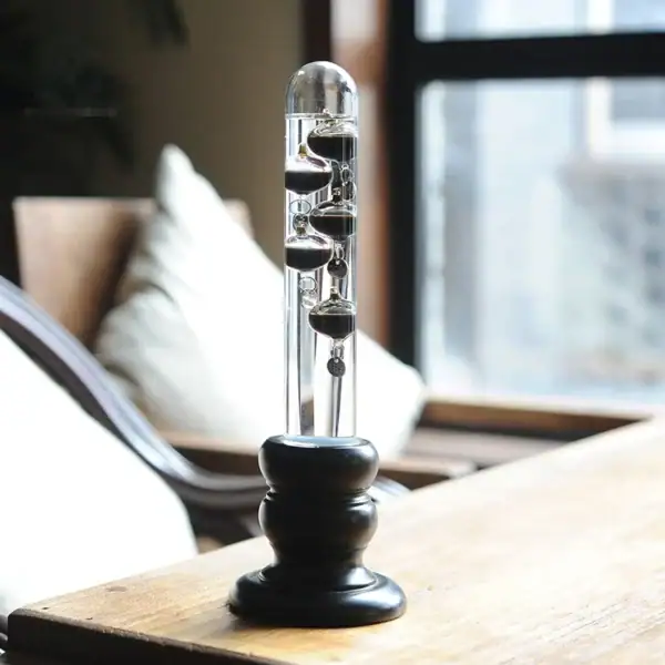 Instrument scientifique de laboratoire avec liquide et billes flottantes dans un environnement intérieur moderne.