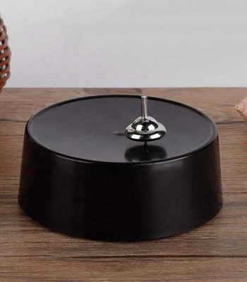 Porte-bougie décoratif inspiré de la science, en métal noir avec une boule en acier brillant au centre.