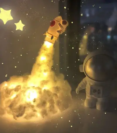 Vaisseau spatial en plastique lumineux avec nuage de fumée, décor scientifique pour enfants, idéal pour une décoration ludique et éducative sur le thème de l'espace.