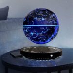 Globe céleste lumineux avec constellations et étoiles, projeté sur une surface noire, illuminant la pièce avec un effet stellaire.