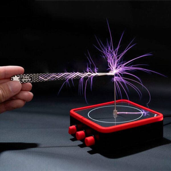 Pointeuse électrique générant des étincelles violettes, posée sur une surface noire, avec une main tenant l'appareil.