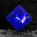 Pierre en résine bleue brillante avec effets lumineux et inclusions scintillantes, conçue pour la décoration et la collection scientifique.