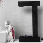 Porte-bouteilles de décoration scientifique en métal noir avec goutte d'eau suspendue, idéal pour une décoration moderne et originale dans un espace de style scientifique ou industriel.