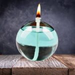 Boule de cire à la flamme allumée flottant dans un récipient en verre, créant une ambiance chaleureuse et scientifique.