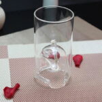 Verre transparent avec modèle de squelette humain miniature à l'intérieur, idéal pour la décoration scientifique ou éducative.