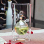 Expérience de chimie avec flamme de sécurité dans un récipient en verre.