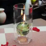 Porte-bougie en verre contenant une bougie allumée, idéal pour la décoration scientifique ou de laboratoire.