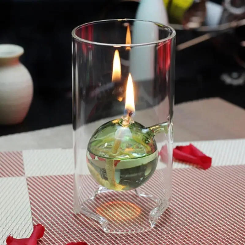 Porte-bougie en verre contenant une bougie allumée, idéal pour la décoration scientifique ou de laboratoire.