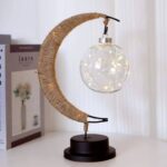 Lustre décoratif en forme de lune avec guirlande lumineuse en verre, parfait pour une décoration intérieure originale et élégante.