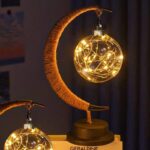 Lustre lunaire avec boule en verre illuminée par des guirlandes LED chaudes, créant une ambiance chaleureuse et féerique.