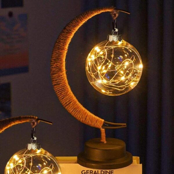 Lustre lunaire avec boule en verre illuminée par des guirlandes LED chaudes, créant une ambiance chaleureuse et féerique.