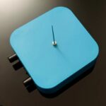 Horloge de laboratoire minimaliste avec cadran numérique bleu et boutons de réglage noirs, conçue pour la décoration scientifique.