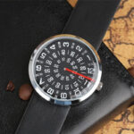 Montre à affichage unique avec chiffres noirs et fond blanc, bracelet en cuir noir, affichage de l'heure, minutes et secondes, design moderne et élégant.