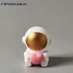 Poupée astronautique en céramique blanche, visage doré et cœur rose, idéale pour la décoration scientifique ou comme cadeau original.