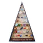 Collection de pierres semi-précieuses variées dans un triangle en verre, illustrant la diversité des minéraux précieux et leur beauté naturelle.