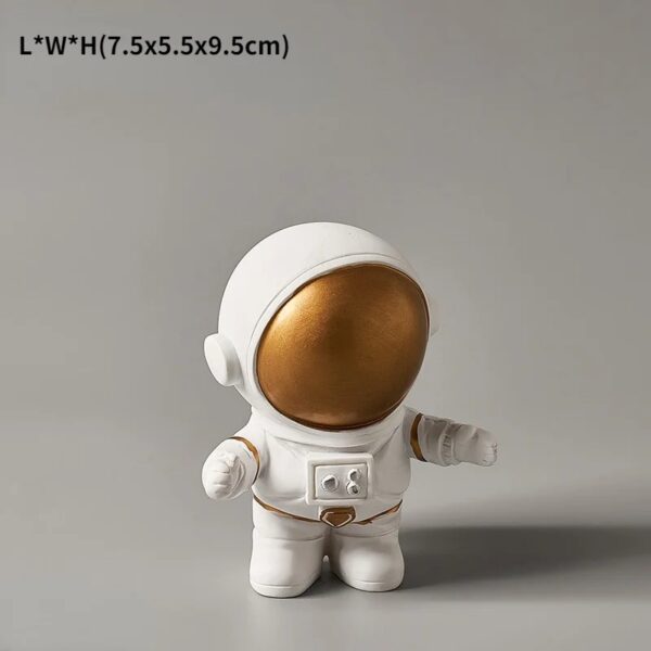 Petite figurine d'astronaute en peluche blanche avec casque doré, idéale pour la décoration ou comme cadeau scientifique pour enfants et amateurs d'espace.