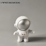 Petite figurine de vaisseau spatial avec casque argenté et corps blanc, idéale pour la décoration scientifique ou pour les amateurs d'objets insolites.