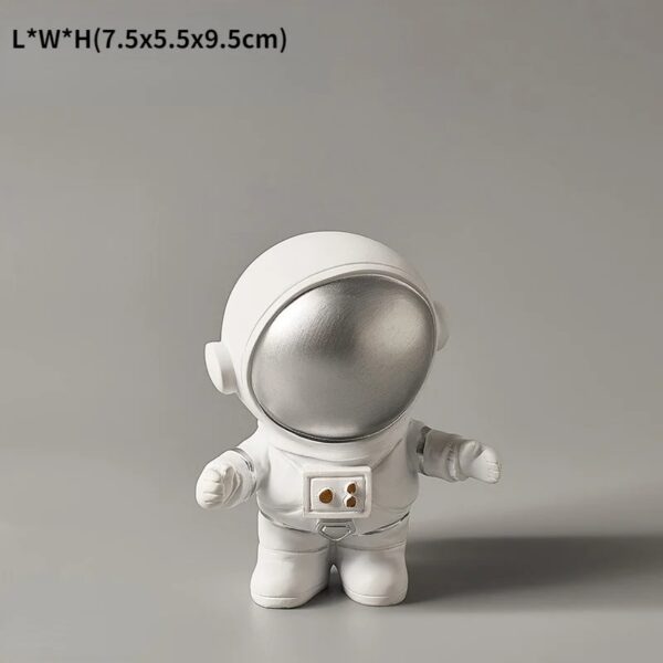Petite figurine de vaisseau spatial avec casque argenté et corps blanc, idéale pour la décoration scientifique ou pour les amateurs d'objets insolites.