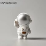 Figurine d'astronaute en décoration de style scientifique, avec casque argenté brillant et combinaison blanche, idéale pour la décoration de bureau ou d'espace dédié à la science.
