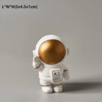 Vase en forme d'astronaute avec tĂȘte dorĂ©e, idĂ©al pour la dĂ©coration intĂ©rieure ou comme objet de collection.