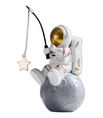 Figurine d'astronaute assis sur la lune, tenant une canne à pêche avec une étoile en pendentif, décor de style scientifique et ludique.