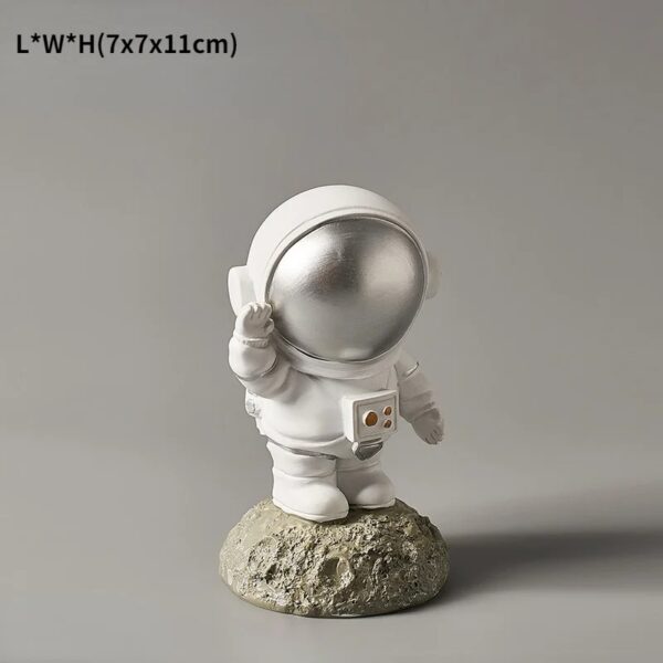 Figurine d'astronaute en résine blanche avec casque brillant, posée sur une base rocheuse. Idéal pour la décoration scientifique ou thématique, apportant une touche d'aventure spatiale à votre intérie.