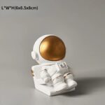 Figurine décorative d'astronaute en or et blanc, idéale pour la décoration intérieure ou comme objet de collection sur le thème de l'espace.